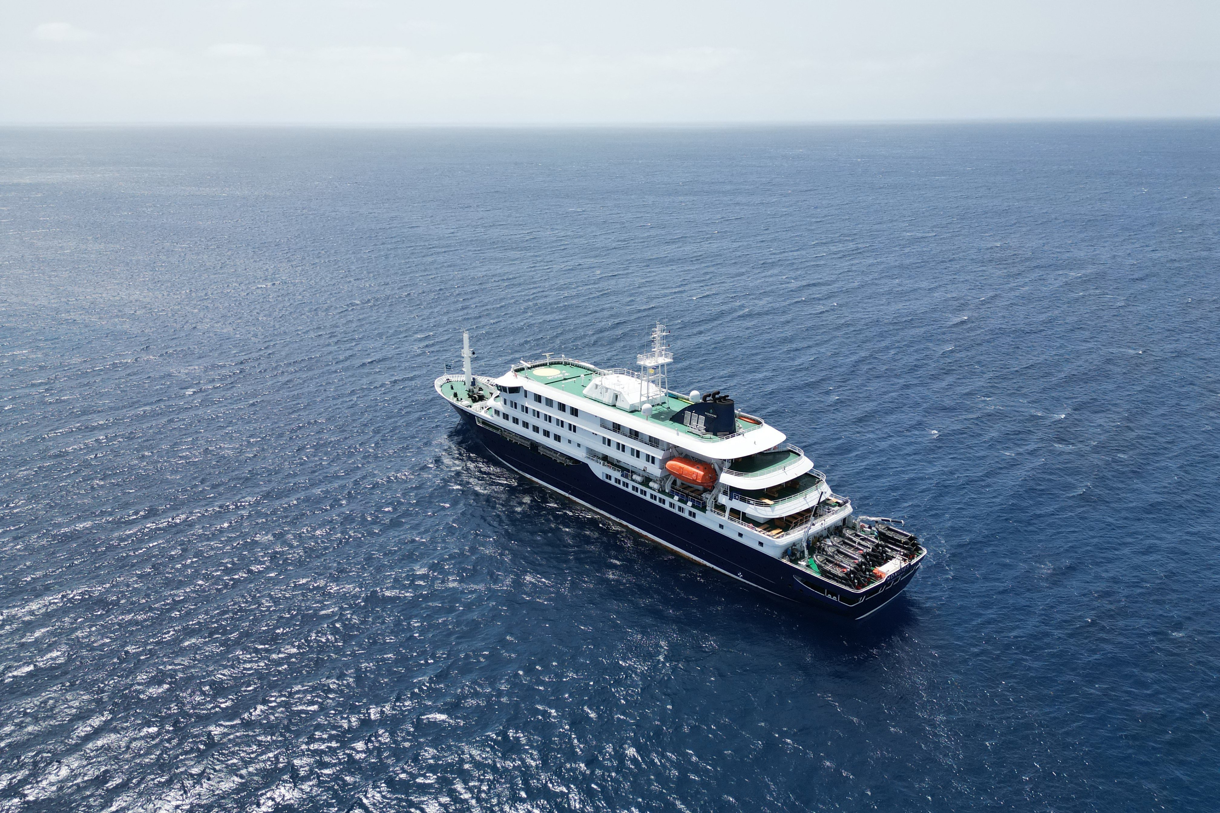 Navio de cruzeiro MV Hondius fundeado ao largo, isolado no mar, como parte de uma operação de quarentena devido a um surto de hantavírus a bordo.