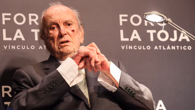 Francisco Pinto Balsemão, idoso, sentado num palco durante um evento formal, com fundo que indica 'Foro La Toja', em contexto de homenagem e reconhecimento público.